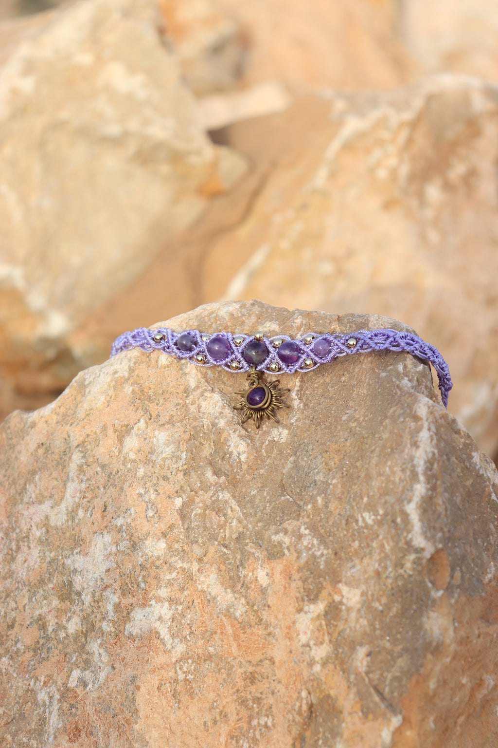 Purple beaded bracelet on a rock